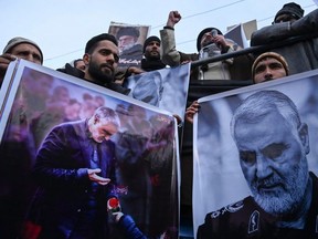 Protesters shout slogans against the United States and Israel as they hold posters with the image of top Iranian commander Qasem Soleimani, who was killed in a U.S. air strike in Iraq, and Iranian President Hassan Rouhani during a demonstration in the Kashmiri town of Magam on Jan. 3, 2020.