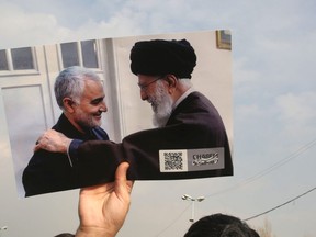 A man holds a picture of Iran's supreme leader Ayatollah Ali Khamenai with Iranian Revolutionary Guards top commander Qasem Soleimani (L) during a demonstration in Tehran on January 3, 2020 against the killing of the top commander in a US strike in Baghdad. (Photo by ATTA KENARE/AFP via Getty Images)