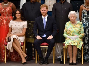 Queen Elizabeth, Prince Harry and Meghan, the Duchess of Sussex, pose for a picture in London, June 26, 2018. *John Stillwell/Pool via Reuters/File Photo)