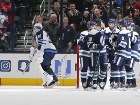The Blue Jackets celebrate Seth Jones’ goal against the Jets as goaltender Laurent Brossoit skates away during the first period on Wednesday night at Nationwide Arena in Columbus. The Jets dropped their fourth consecutive contest. (USA TODAY SPORTS)