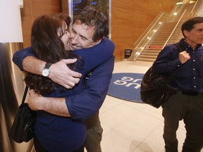 Manitoba firefighters Andrew Prokopchuk gets a hug from his wife Patti as he and Gerry Rosset return from fighting fires in Australia at the airport in Winnipeg Thursday, January 9, 2020.