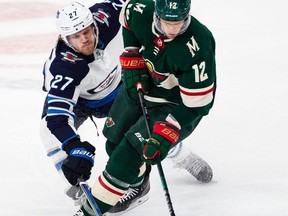 Jan 4, 2020; Saint Paul, Minnesota, USA; Minnesota Wild center Eric Staal (12) and Winnipeg Jets left wing Nikolaj Ehlers (27) fight for the puck during the third period at Xcel Energy Center. Mandatory Credit: Harrison Barden-USA TODAY Sports