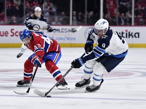 Jan 6, 2020; Montreal, Quebec, CAN; Winnipeg Jets forward Andrew Copp (9) plays the puck /and Montreal Canadiens forward Jordan Weal (43) defends during the third period at the Bell Centre. Mandatory Credit: Eric Bolte-USA TODAY Sports