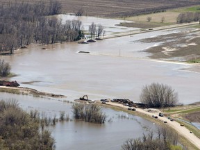 The breach in the dike at the hoop and holler bend is seen along the Assiniboine River outside of Portage La Prairie, Man, Saturday, May 14, 2011. A Manitoba First Nation is heading to court arguing the federal government is cutting off evacuee benefits without providing secure housing more than eight years after flooding forced the community to leave their homes.