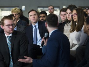 Canadian federal Finance Minister Bill Morneau, back centre, listens to a question from a Ryerson University student as he launches consultations for the Budget 2020 at a town hall discussion in Toronto on Monday, January 13, 2020.