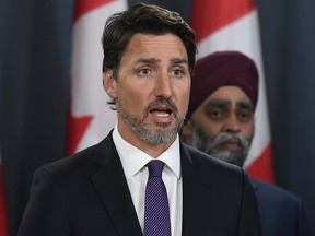 Prime Minister Justin Trudeau holds a news conference updating the Iran plane crash in Ottawa on Thursday, Jan. 9, 2020, as Defence Minister Harjit Sajjan looks on.