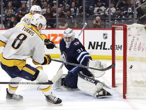 Nashville Predators centre Kyle Turris scores what proved to be the game winner on Winnipeg Jets goaltender Connor Hellebuyck during the first period at Bell MTS Place on Sunday. (James Carey Lauder/USA TODAY Sports)