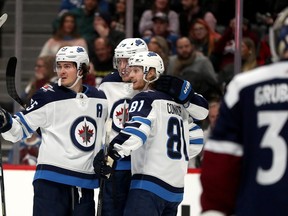 DENVER, COLORADO - DECEMBER 31: Mark Scheifele #55, Jack Roslovic #28 and Kyle Connor #81 of the Winnipeg Jets celebrate a goal by Connor against the Colorado Avalanche in the third period at the Pepsi Center on December 31, 2019 in Denver, Colorado.