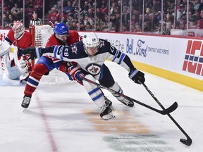 Marco Scandella of the Montreal Canadiens challenges Jack Roslovic of the Winnipeg Jets as he skates the puck during the third period at the Bell Centre on Monday in Montreal. The Jets defeated the Canadiens 3-2.