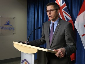 Mayor Brian Bowman speaks about a lawsuit related to Winnipeg Police Service headquarters at City Hall in Winnipeg on Monday.