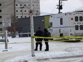 Two Winnipeg Police Service officers from the Forensics Unit outside of the Windsor Hotel in the 100 block of Garry Street in downtown Winnipeg on Sunday, Jan. 12, 2020. Officers were called to the area in the early morning on Sunday, Jan. 12, 2020, for the reports of shots had been fired. Three men were taken to hospital in critical condition and one later died from his injuries. GLEN DAWKINS/Winnipeg Sun/Postmedia Network
