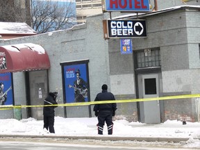 Two Winnipeg Police Service officers from the Forensics Unit outside of the Windsor Hotel in the 100 block of Garry Street in downtown Winnipeg on Sunday. Early Sunday morning, the Winnipeg Police received a report of shots that had been fired at the hotel.