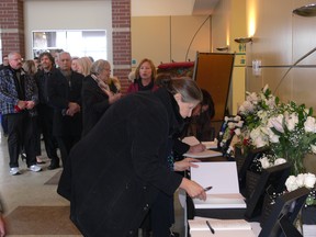 Mourners sign condolence books at a memorial service for the Manitoba victims of Ukraine Flight PS752 at Centro Caboto Centre in Winnipeg on Sunday. They died when their plane was shot down last week in Tehran.