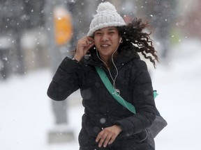 Larissa runs across Stradbrook Avenue, on Osborne Street, in the early moments of a heavy snowfall in Winnipeg on Friday.