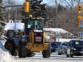 Vehicles avoid a loader clearing snow along Corydon Avenue near Cambridge Street in the River Heights area of Winnipeg on Mon., Jan. 20, 2020. Kevin King/Winnipeg Sun/Postmedia Network