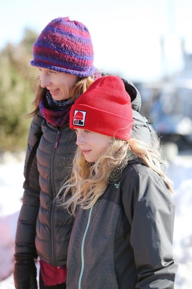 Candance Russell-Summers and her 10-year-old daughter Madeline Summers watch the wood carving challenge on the final day of the 51st annual Festival du Voyageur in Winnipeg, Man., on Sunday, Feb. 23, 2020. (Brook Jones/Postmedia Network)