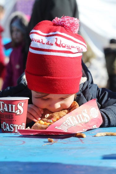 Four-year-old Henry Lask enjoys a beaver tail from BeaverTails Pastries while attending the final day of the 51st anniversary of Festival du Voyageur in Winnipeg, Man., on Sunday, Feb. 23, 2020. (Brook Jones/Postmedia Network)