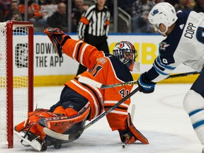 Edmonton Oilers' goaltender Mike Smith (41) stops Winnipeg Jets' Andrew Copp (9) during second period NHL hockey action at Rogers Place in Edmonton on Saturday, Feb. 29.