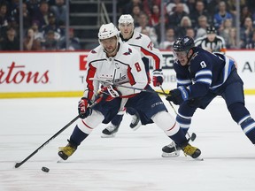 Jets' Andrew Copp (9) attempts to get  Capitals' Alex Ovechkin (8) off the puck during second period on Thursday, February 27, 2020. THE CANADIAN PRESS/John Woods