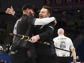 Team McEwen skip Mike McEwen, middle, celebrates his win with second Derek Samagalski as Team Howard skip Glenn Howard, right, walks off following the wild card game at the Brier in Kingston, Ont., on Friday, Feb. 28, 2020. THE CANADIAN PRESS/Sean Kilpatrick