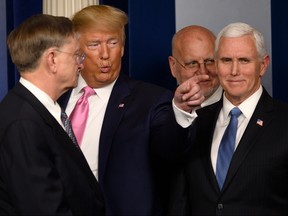 U.S. President Donald Trump, second from left, gestures, flanked by Vice President Mike Pence, right, after speaking at a news conference on the COVID-19 outbreak at the White House on Feb. 26, 2020. (ANDREW CABALLERO-REYNOLDS/AFP via Getty Images)