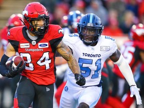 Calgary Stampeders Reggie Begelton takes off with the ball under pressure from Micah Awe of the Toronto Argonauts during CFL football in Calgary on Thursday, July 18, 2019. Al Charest/Postmedia