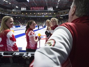 Team Canada skip Chelsea Carey, from left to right, lead Rachel Brown, second Dana Ferguson and third Sarah Wilkes speak to their coach Dan Carey prior to the 4th draw against Saskatchewan at the Scotties Tournament of Hearts in Moose Jaw, Sask., Sunday, Feb. 16, 2020.