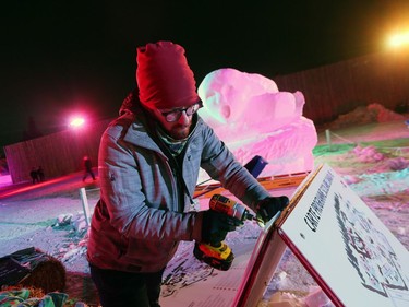 Festival du Voyageur sign coordinator Nathan Sawatzky-Dyck puts the finishing touches on a sign just outside Fort Gibraltar on the opening day of Festival du Voyageur in Winnipeg, Man., on Friday, Feb. 14, 2020. The 51st annual Festival du Voyageur runs from Feb. 14 to 23, 2020.