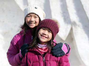 Festival goers are all smiles as they stand in front of a snow sculpture while attending the finaly day of the 51st annual Festival du Voyageur in Winnipeg, Man., on Sunday, Feb. 23, 2020.