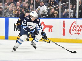 Feb 23, 2020; Buffalo, New York, USA; Winnipeg Jets center Cody Eakin (20) controls the puck in front of Buffalo Sabres defenseman Rasmus Dahlin (26) in the first period at KeyBank Center. Mandatory Credit: Mark Konezny-USA TODAY Sports