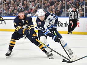 Feb 23, 2020; Buffalo, New York, USA; Winnipeg Jets center Mark Scheifele (55) and Buffalo Sabres center Jack Eichel (9) contend for the puck in the first period at KeyBank Center. Mandatory Credit: Mark Konezny-USA TODAY Sports