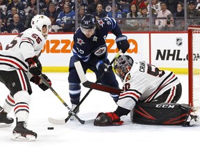 Chicago Blackhawks defenceman Nick Seeler (55) and Winnipeg Jets center Mark Scheifele (55) scramble for the puck in front of Chicago Blackhawks goaltender Corey Crawford (50) in the second period at Bell MTS Place on Sunday.
