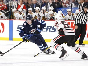 Feb 16, 2020; Winnipeg, Manitoba, CAN;  Winnipeg Jets right wing Patrik Laine (29) skates up the ice towards Chicago Blackhawks defenseman Nick Seeler (55) in the second period at Bell MTS Place. Mandatory Credit: James Carey Lauder-USA TODAY Sports