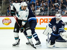 Winnipeg Jets goalie Connor Hellebuyck (37) makes a save with San Jose Sharks forward Evander Kane (9) looking for a rebound during the first period at Bell MTS Place on Friday. Kane drew a three-game suspension for his high hit on Jets defenceman Neal Pionk.