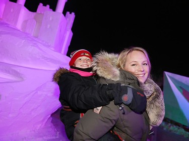 Ile des Chênes resident Tammy Kasdorf has her nine-year-old daughter Zara on her shoulders while they check out a snow sculpture on the opening day of Festival du Voyageur in Winnipeg, Man., on Friday, Feb. 14, 2020. The 51st annual Festival du Voyageur runs from Feb. 14 to 23, 2020.