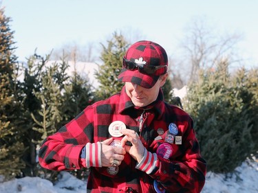 James Torrance adjusts one of his Festival du Voyageur buttons while attending the final day of the 51st annual Festival du Voyageur in Winnipeg, Man., on Sunday, Feb. 23, 2020.