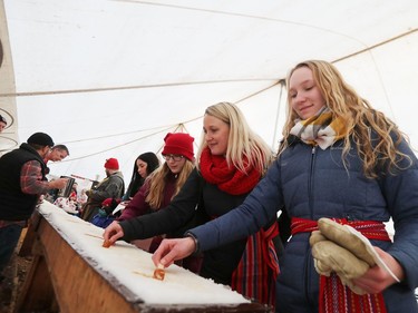 L-R: Brooklynne, Chris and Kendra Grieger enjoy taffy on snow while attending Festival du Voyageur in Winnipeg, Man., on Sunday, Feb. 16, 2020. The 51st annual Festival du Voyageur in Winnipeg, Man., runs from Feb. 14 to 23, 2020.