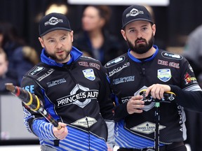 Mike McEwen (left) and Reid Carruthers talk strategy during last year’s Viterra provincial men’s curling championship in Virden, Man. (KEVIN KING/WINNIPEG SUN FILES)