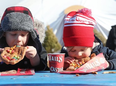 Seven-year-old Charlie Lask and his four-year-old brother enjoy beaver tails from BeaverTails Pastries while attending the final day of the 51st anniversary of Festival du Voyageur in Winnipeg, Man., on Sunday, Feb. 23, 2020.