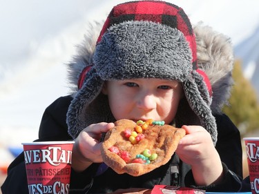 Seven-year-old Charlie Lask enjoys a beaver tail from BeaverTails Pastries while attending the final day of the 51st anniversary of Festival du Voyageur in Winnipeg, Man., on Sunday, Feb. 23, 2020.