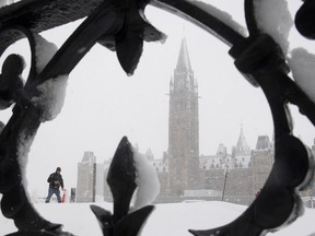 A man walks on Parliament Hill during a snow storm in Ottawa, Thursday, Feb. 27, 2020. Over 25cm of snow was expected to fall on the region as a winter storm passed through.