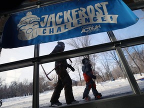 Skaters pass by signage during the launch for the Jack Frost Challenge at Assiniboine Park in Winnipeg on Sunday.