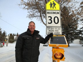 Chuck Lewis poses for a photograph with a solar-powered flashing light he installed on a school zone warning sign on Bedson Street, near Winnipeg Mennonite Elementary School, in Winnipeg on Thurs., Feb. 6, 2020. Kevin King/Winnipeg Sun/Postmedia Network