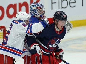 Winnipeg Jets forward Patrik Laine (right) absorbs a shot from New York Rangers defenceman Ryan Lindgren in Winnipeg on Tuessday. Kevin King/Winnipeg Sun/Postmedia Network