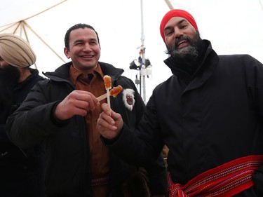 Jagmeet Singh (right), federal New Democratic Party leader, and Wab Kinew, the Manitoba NDP leader, celebrate Louis Riel Day with maple taffy in the Sugar Shack at Festival du Voyageur in Winnipeg on Mon., Feb. 17, 2020. Kevin King/Winnipeg Sun/Postmedia Network