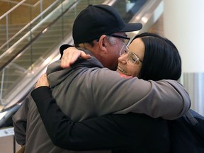 Skip Kerri Einarson is hugged by James Harris after arriving at Winnipeg International Airport on Monday, fresh off winning the national women's curling title in Moose Jaw on Sunday.