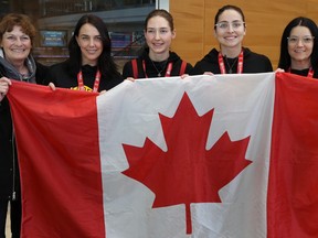 Team Kerri Einarson (from left): coach Patti Wuthrich, alternate Jennifer Clark-Rouire, lead Briane Meilleur, second Shannon Birchard and skip Kerri Einarson, pose with a Canadian flag at Winnipeg International Airport on Mon., Feb. 24, 2020, after winning the national women's curling title in Moose Jaw on Sunday. Third Val Sweeting went straight home to Edmonton. Kevin King/Winnipeg Sun/Postmedia Network