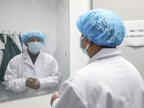 A medical worker gets ready before entering the ward at Jinyintan hospital in Wuhan, the epicentre of the novel coronavirus outbreak, in Hubei province, China, on Thursday, Feb. 13, 2020.