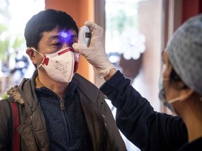 A nurse checks the body temperature of a journalist in the third Covid-19 Hospital before the opening, at Casal Palocco, on March 17, 2020, in Rome, Italy.