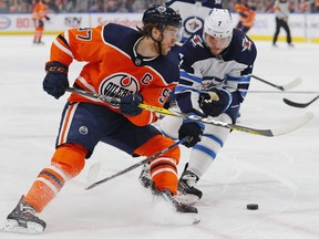 Oilers forward Connor McDavid (left) tries to move the puck around Jets defencemen Dmitry Kulikov during the first period at Rogers Place in Edmonton on March 11, 2020. No one knew it would be the final game of the regular season for the Jets as the world reacted to the COVID-19 pandemic.  Perry Nelson/USA TODAY Sports